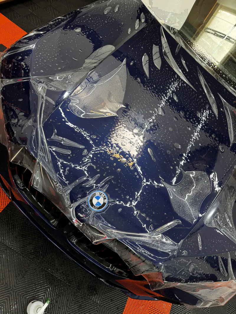 Pose d’un film de protection PPF XPEL sur le capot d’un BMW X5 M50